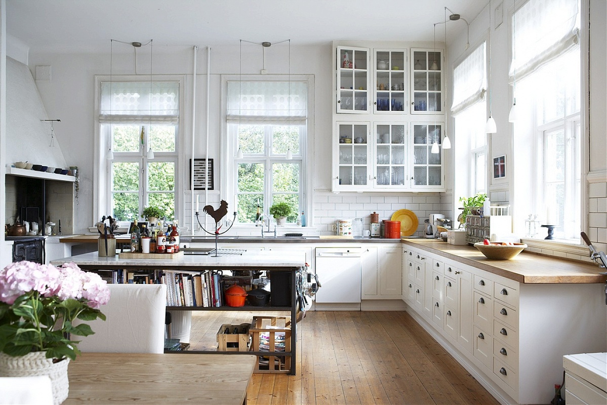 typowy wystrój kuchni w stylu skandynawskim - drewniane ramy okien i drzi szafek w kolorze białym